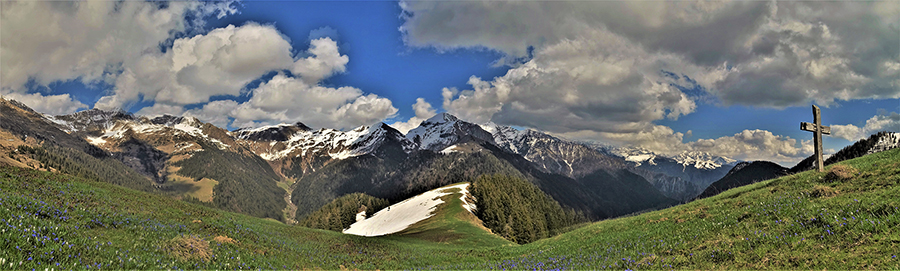 Croce lignea su verdi prati fioriti con splendida vista panoramica